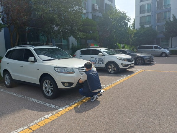 [사진] 체납차량영치반 관계자가 관내 아파트단지에서 체납차량 번호판을 영치하고 있다