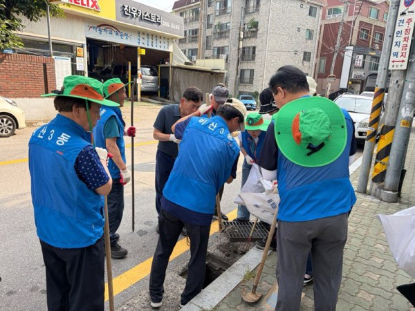 [사진] 비산3동 주민들이 빗물받이에 퇴적된 토사를 정비하고 있다