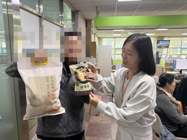 [사진] 매탄3동의 건강 취약계층 가구에 삼계탕과 쌀을 전달하고 있다.