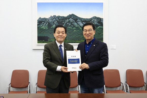 이재준 수원시장(왼쪽)이 신정훈 국회 행정안전위원장에게 건의문을 전달하고 있다.