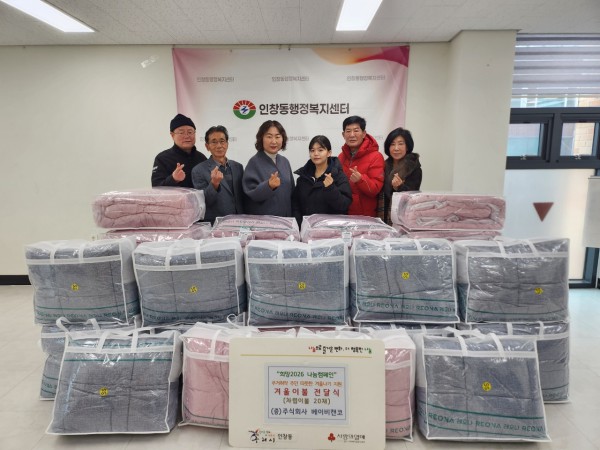 권소미 대표와 김경애 동장이 인창동 행정복지센터에서 이불 전달식을 진행하고 있다.