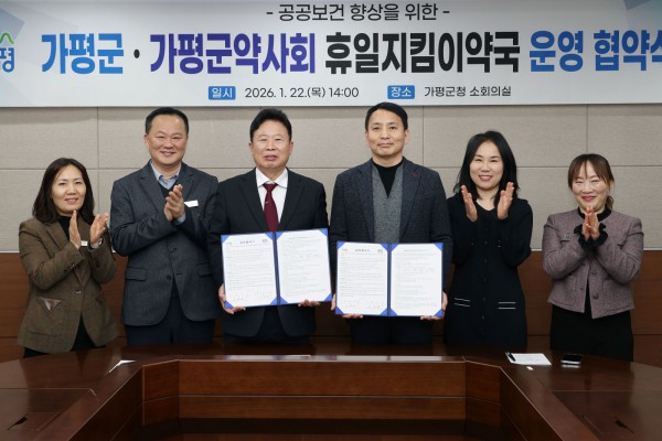 서태원 가평군수(사진 왼쪽에서 세번째)와 안병현 가평군약사회 회장(〃 네번째) 등이 22일 휴일지킴이약국 운영 협약식 후 협약서를 보이며 기념촬영을 하고 있다.