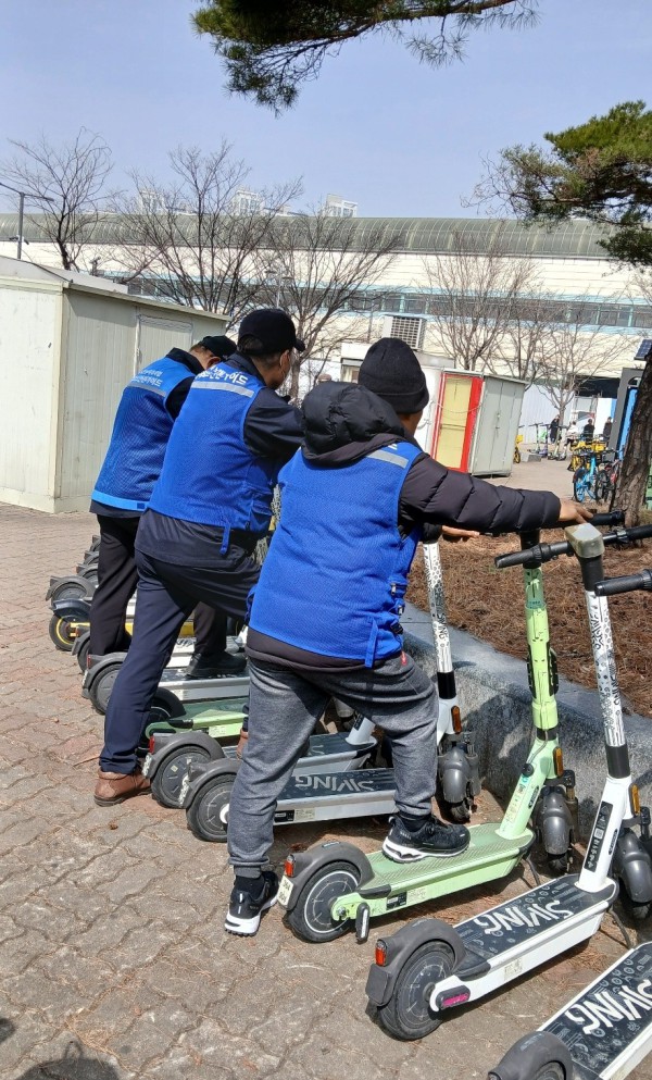 전동킥보드 안전 가이드 사업 참여자들이 무단방치된 전동킥보드를 정리하고 있다.